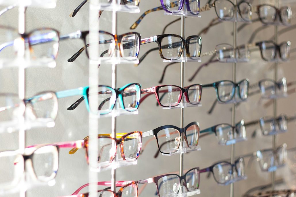 Een wand met brilmonturen in een optiekwinkel